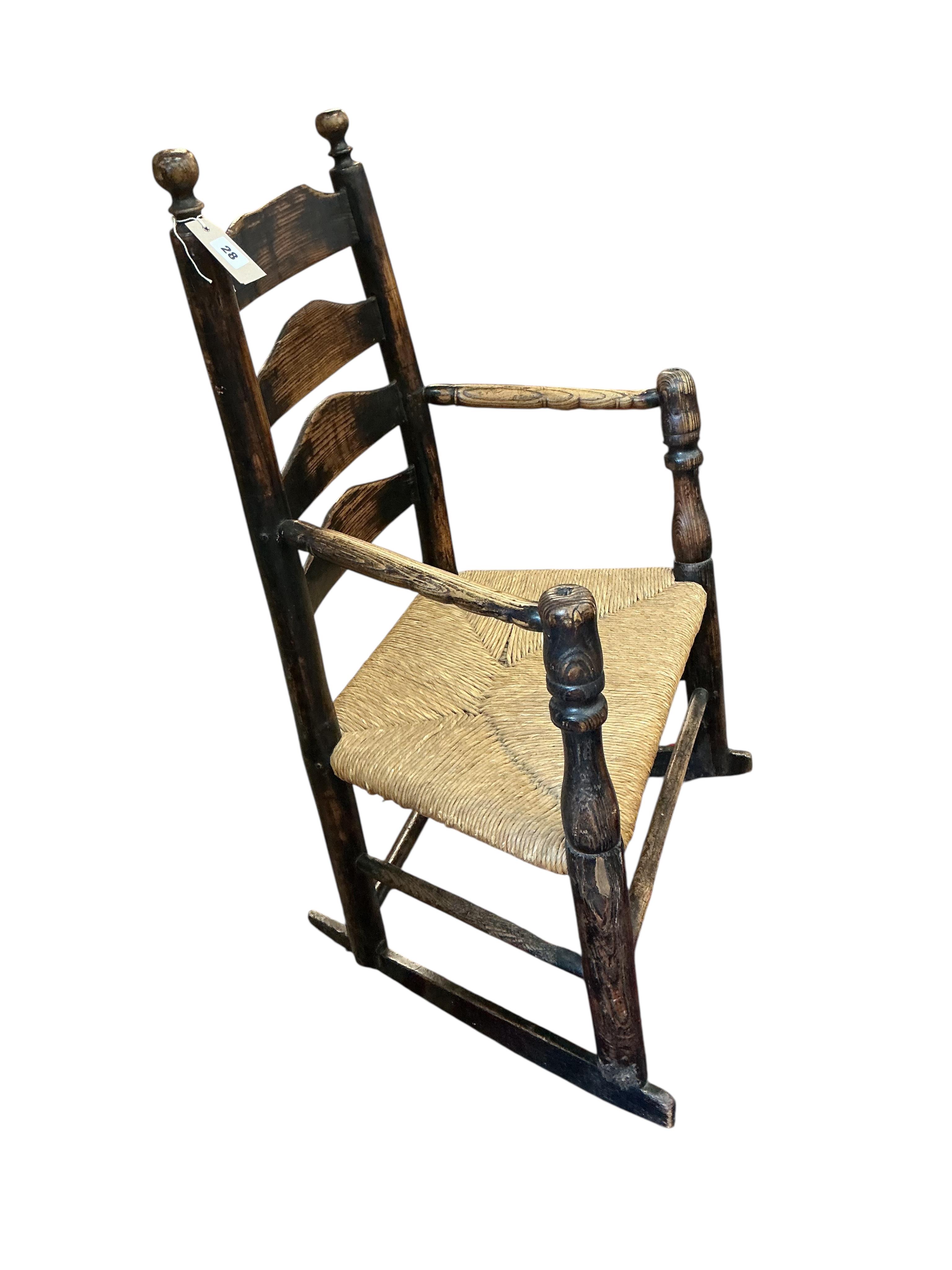 An early 19th century Provincial ash rush seat ladderback rocking chair, width 64cm, depth 41cm, height 95cm